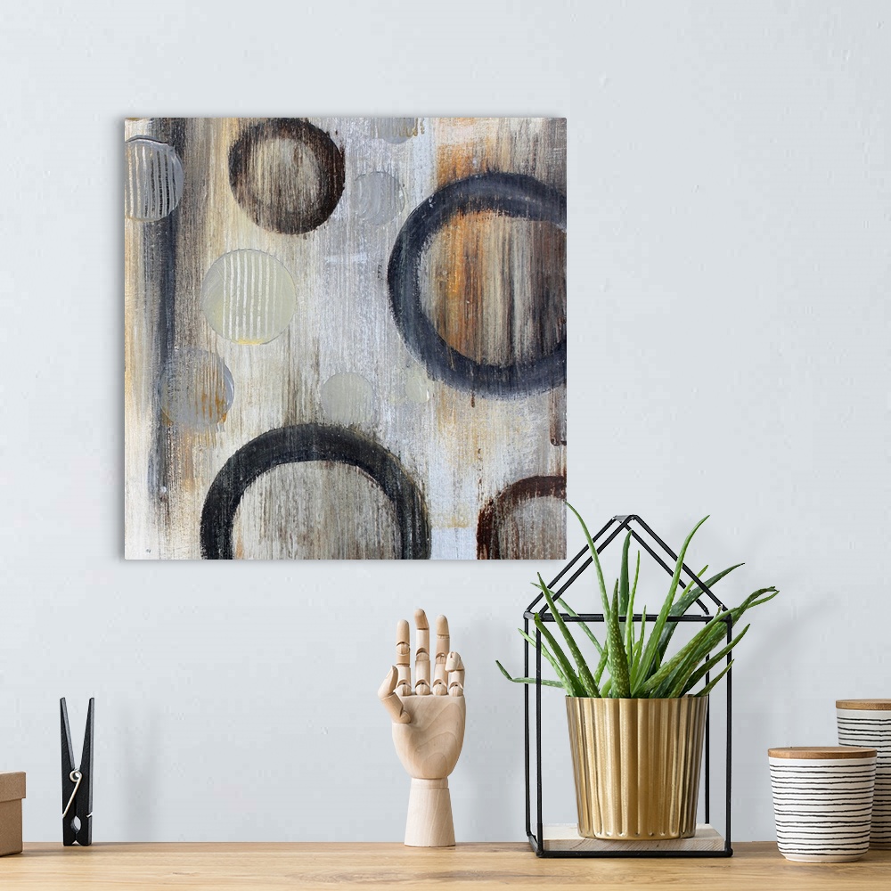 A bohemian room featuring Abstract artwork of circle floating against a gray background with an overall grungy look.