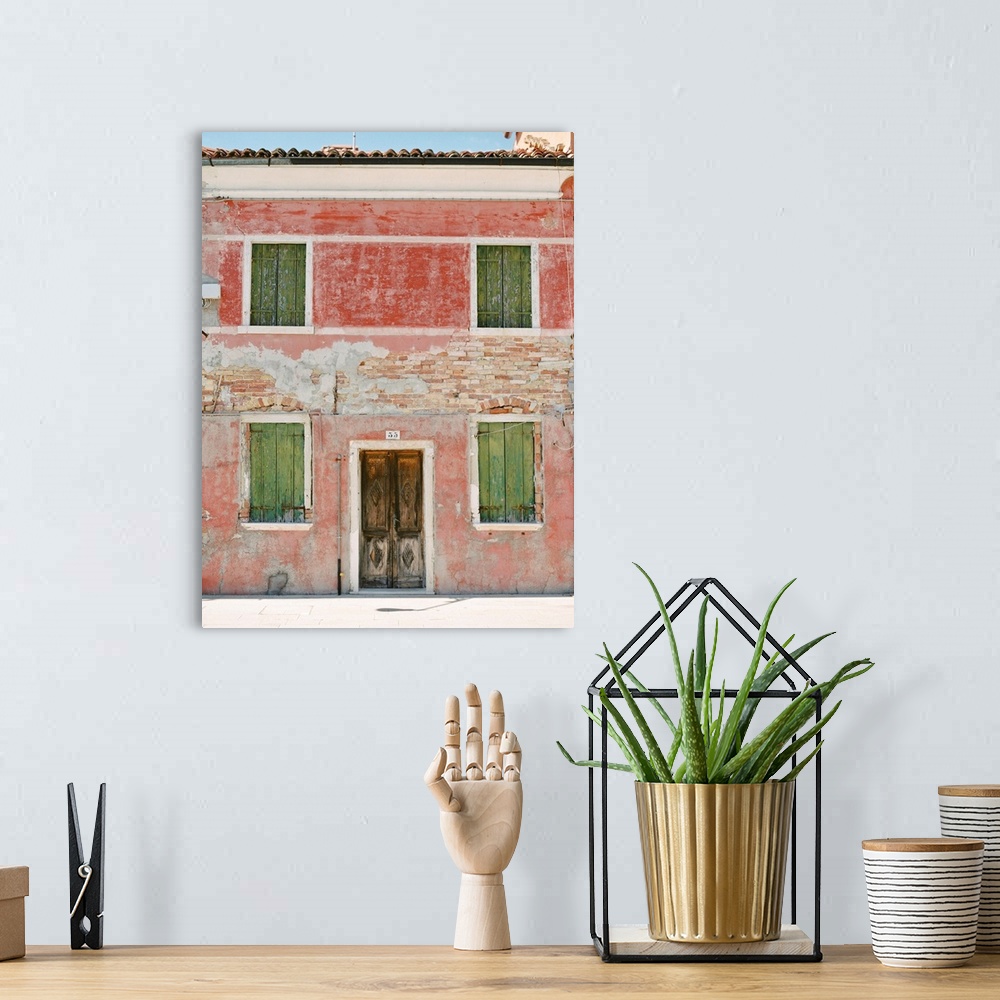 A bohemian room featuring Photograph of a very old building with green shutters and pink walls, Burano, Italy.