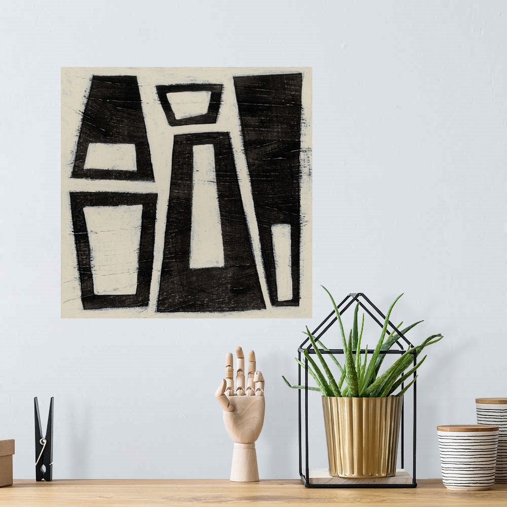 A bohemian room featuring Black and white abstract artwork made of trapezoids.