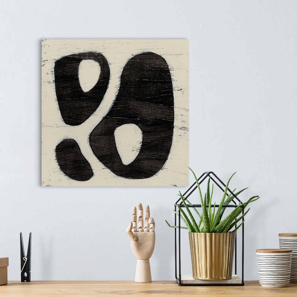 A bohemian room featuring Black and white abstract artwork made of round shapes.