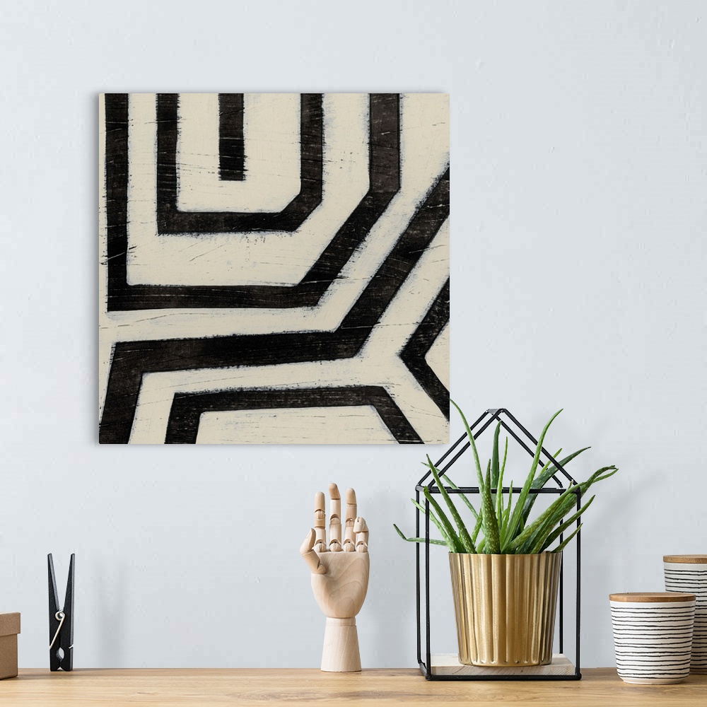 A bohemian room featuring Black and white abstract artwork made of angled lines.