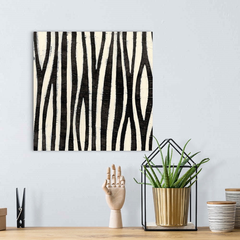 A bohemian room featuring Black and white abstract artwork made of vertical stripes.