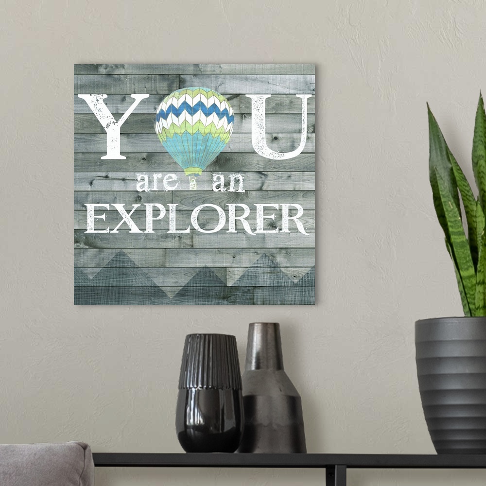 A modern room featuring Inspirational decorative artwork of the phrase "You are an explorer" with a hot air balloon design.