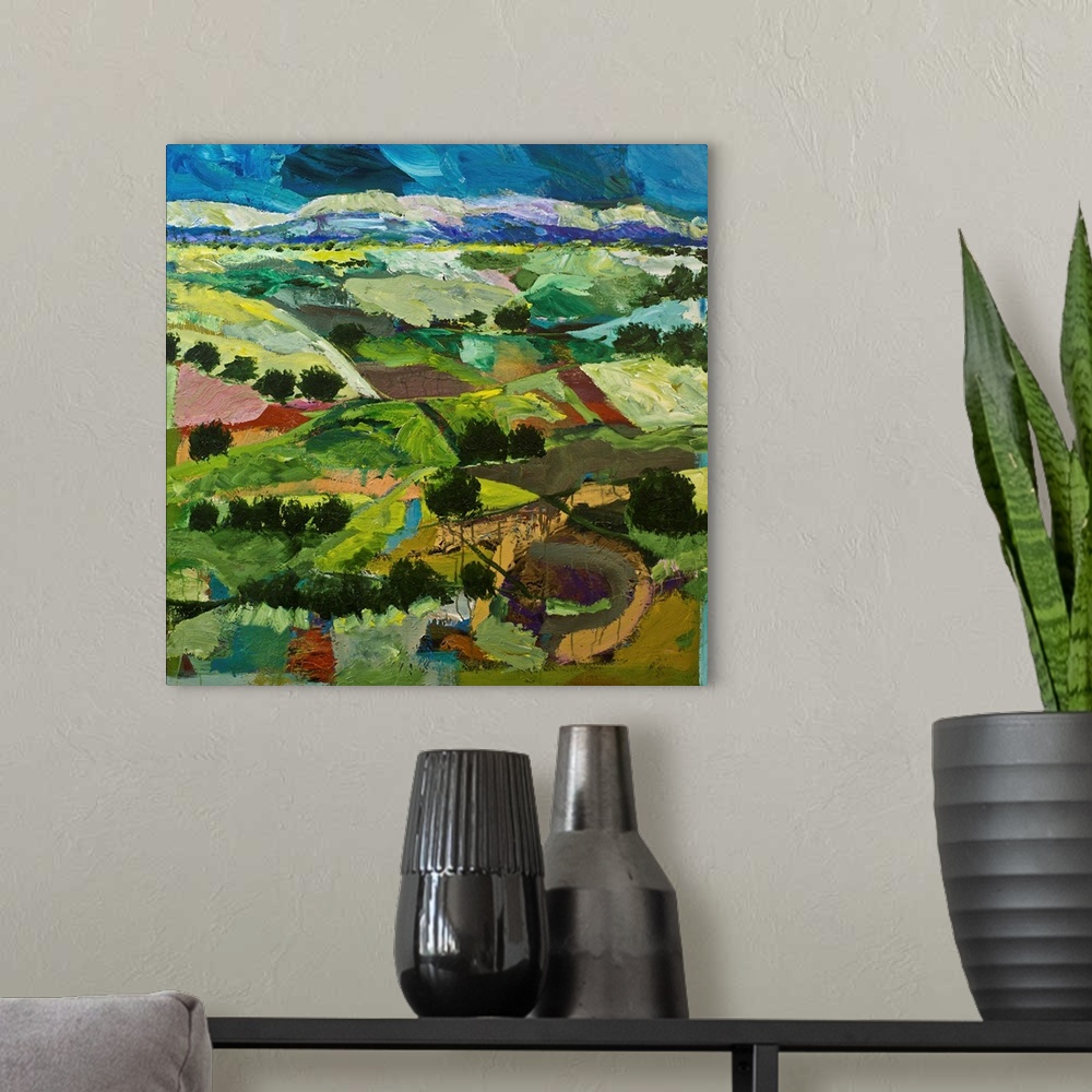A modern room featuring Contemporary painting of a country landscape with many tilled fields lined with trees.