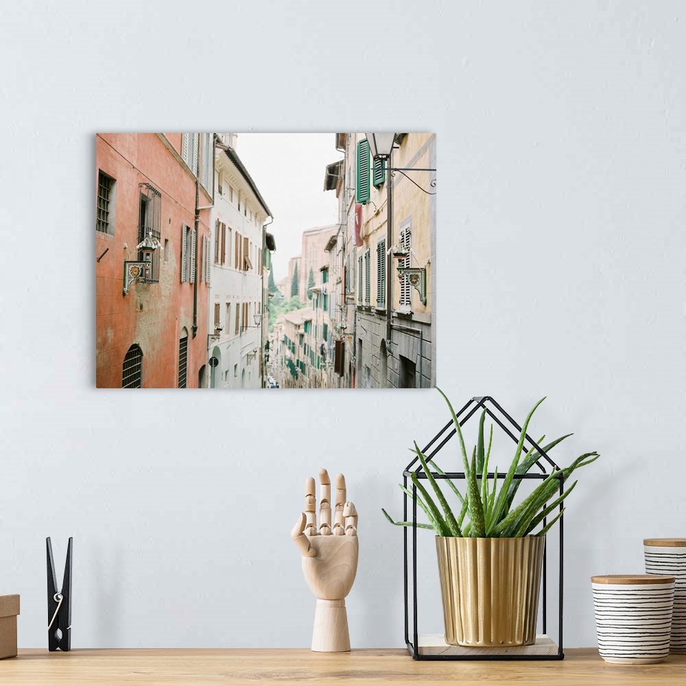 A bohemian room featuring Photograph of a narrow alleyway between two tall buildings adorned with shutters, Italy.