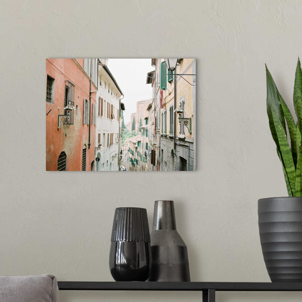 A modern room featuring Photograph of a narrow alleyway between two tall buildings adorned with shutters, Italy.