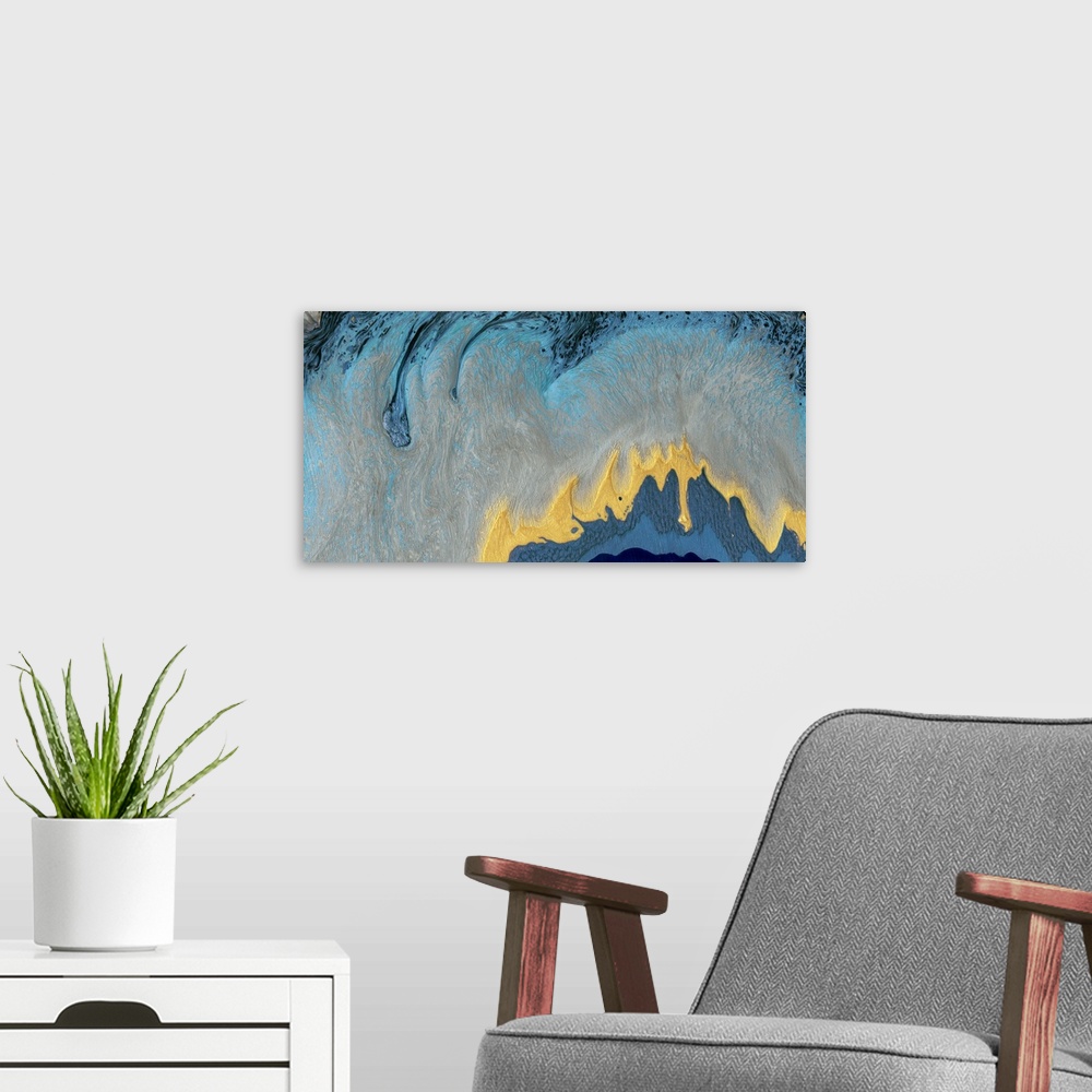 A modern room featuring This contemporary artwork features fluid paint in blue, gray and gold to reflect the elegant moti...