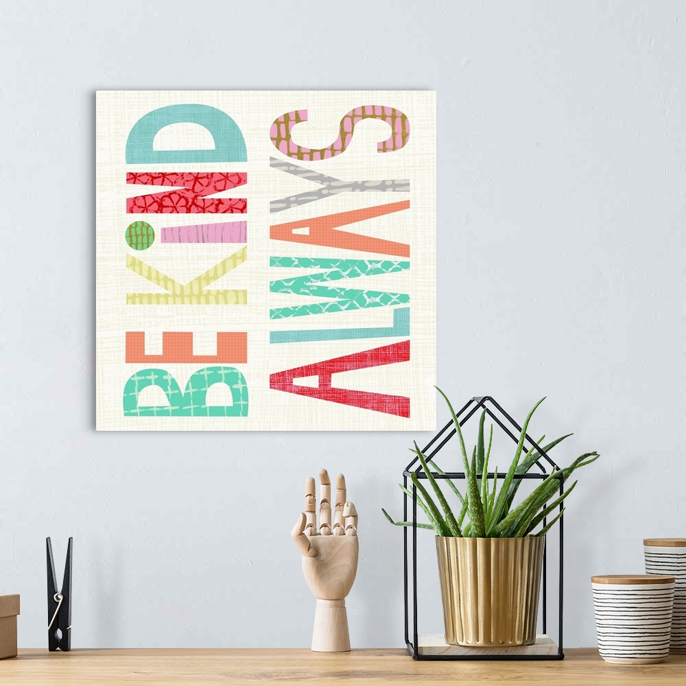 A bohemian room featuring Children's typography artwork in colorful block letters reading "Be Kind Always."