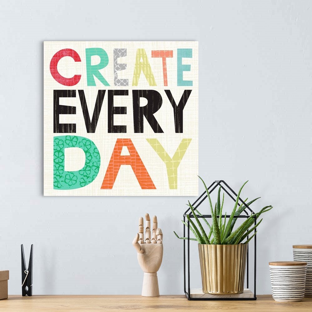 A bohemian room featuring Children's typography artwork in colorful block letters reading "Create Every Day."