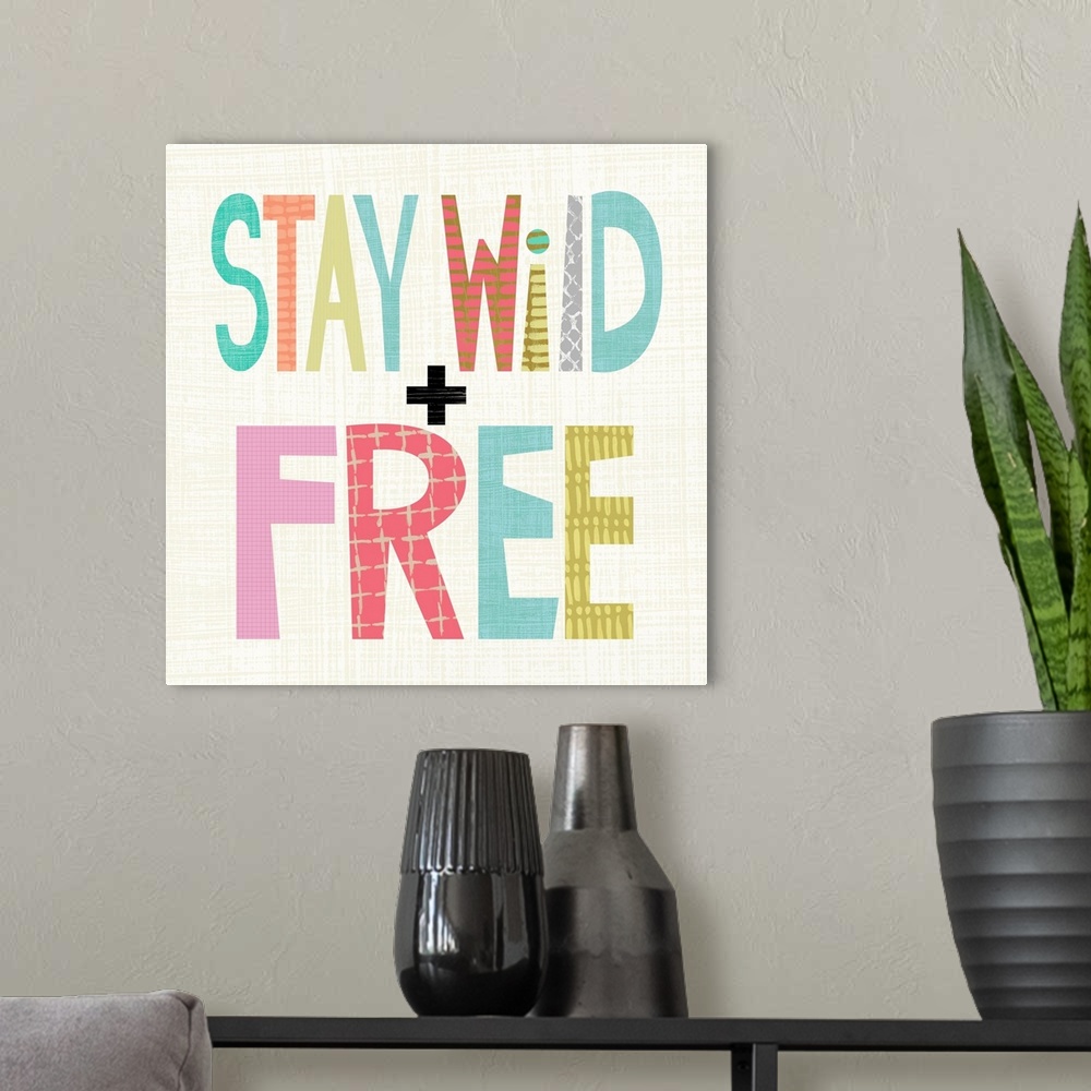 A modern room featuring Children's typography artwork in colorful block letters reading "Stay Wild and Free."