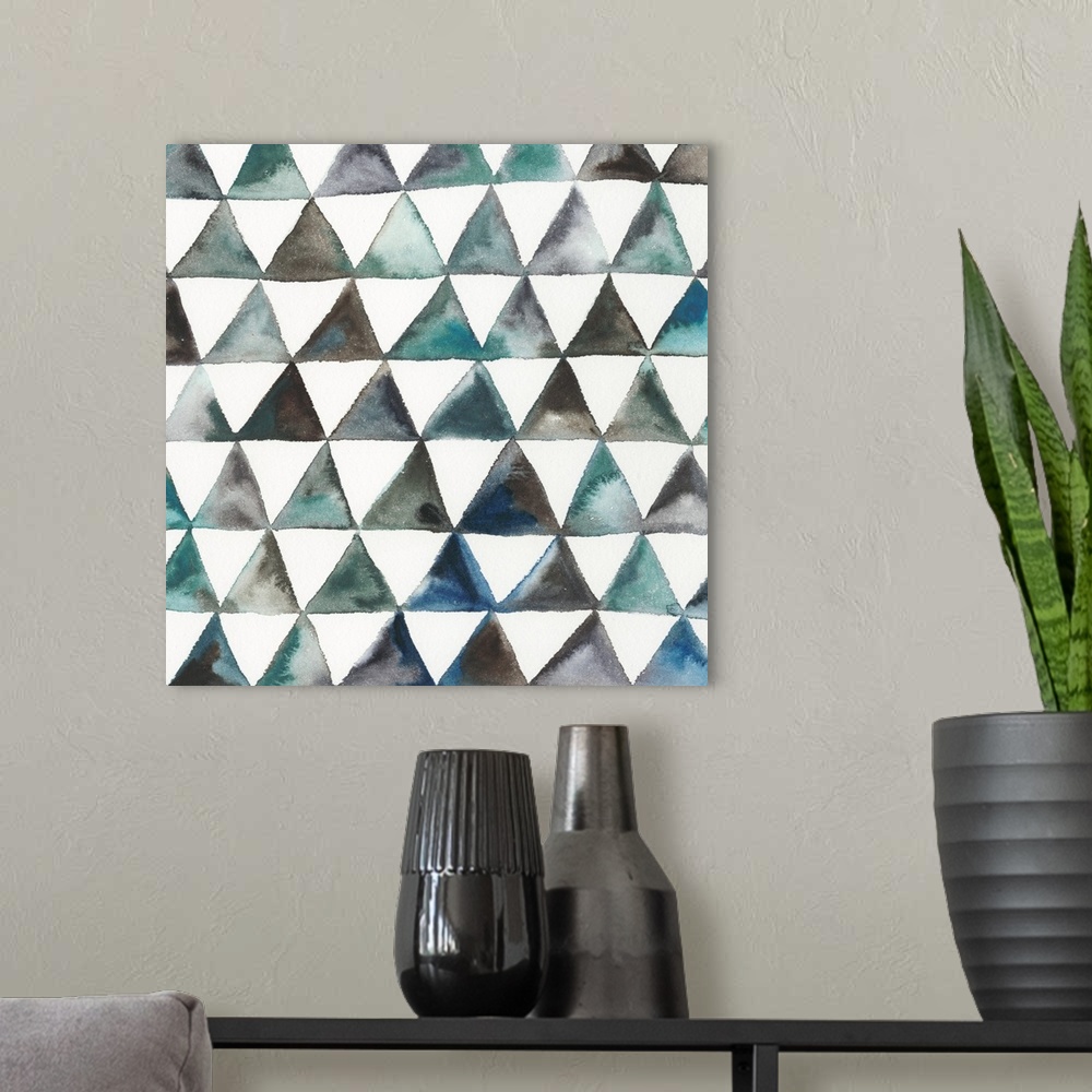A modern room featuring Square abstract decor with triangles in lines creating a pattern in shades of blue, green, and br...