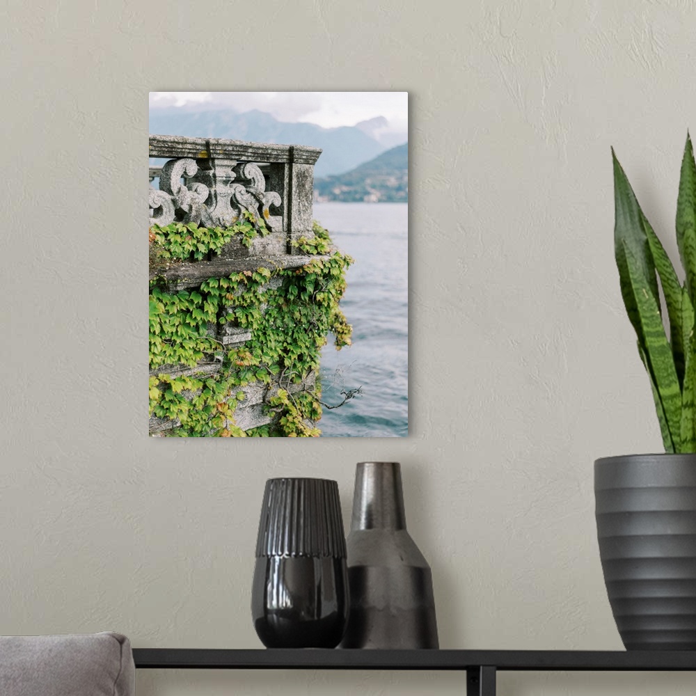 A modern room featuring A photograph of an ornate stone balcony covered with ivy on the shore of Lake Como, Italy.