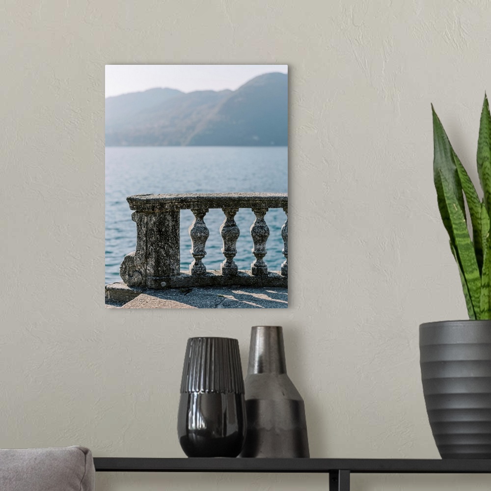 A modern room featuring A photograph of an ornate stone balcony on the shore of Lake Como, Italy.