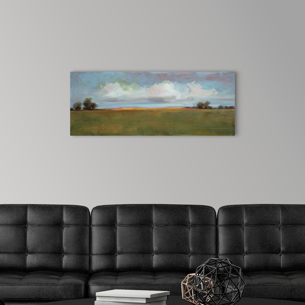 A modern room featuring Contemporary landscape artwork of an open field with sparse trees under a cloudy sky.