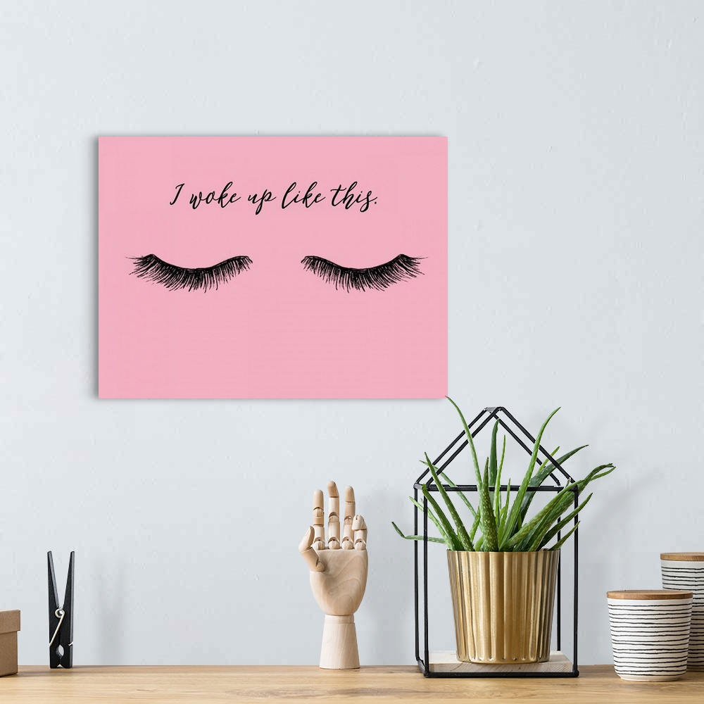 A bohemian room featuring "I Woke Up Like This" with eyelashes in black on a pink background.