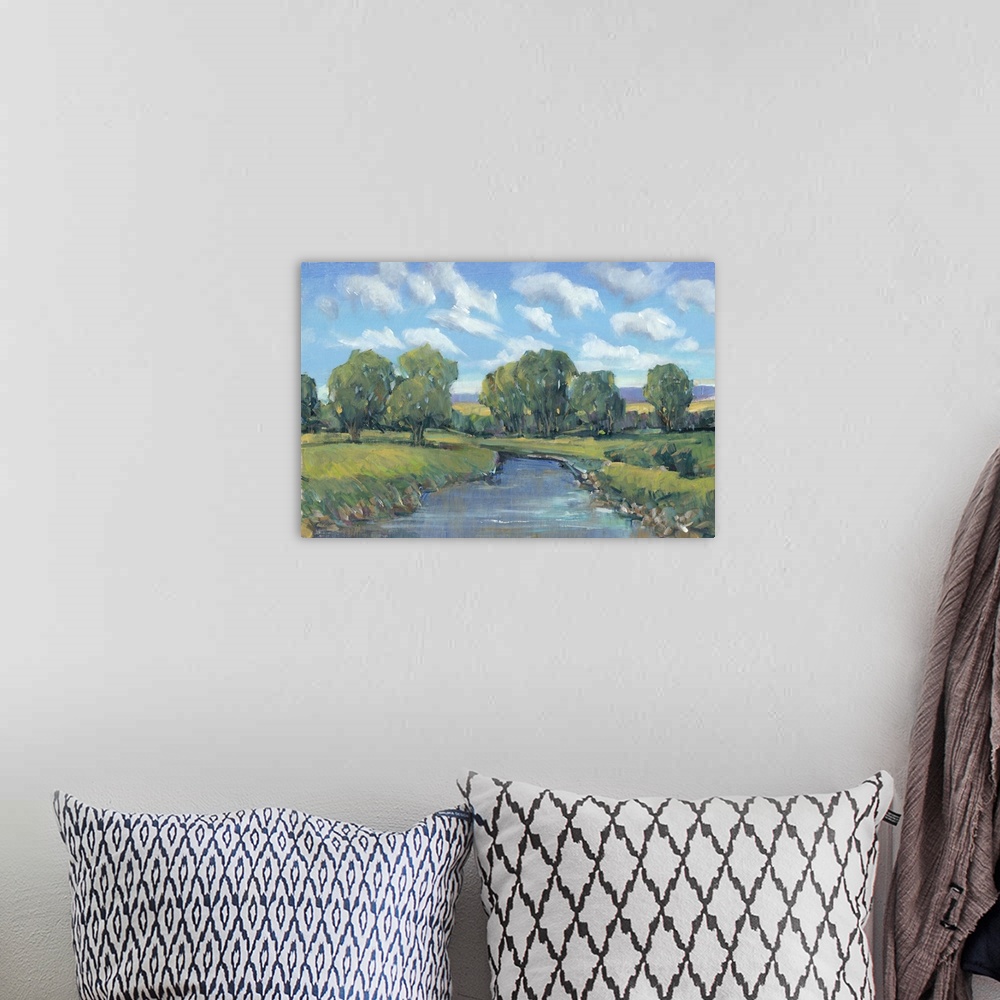 A bohemian room featuring Contemporary artwork of a stream running through a countryside under a blue summer sky.
