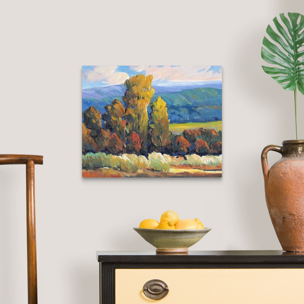 A traditional room featuring Contemporary painting of a mountain valley landscape with a grove of trees in the fall.