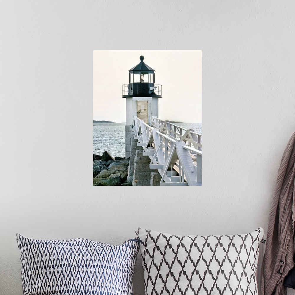A bohemian room featuring A photograph of a lighthouse at the end of a pier jetting out over the water.