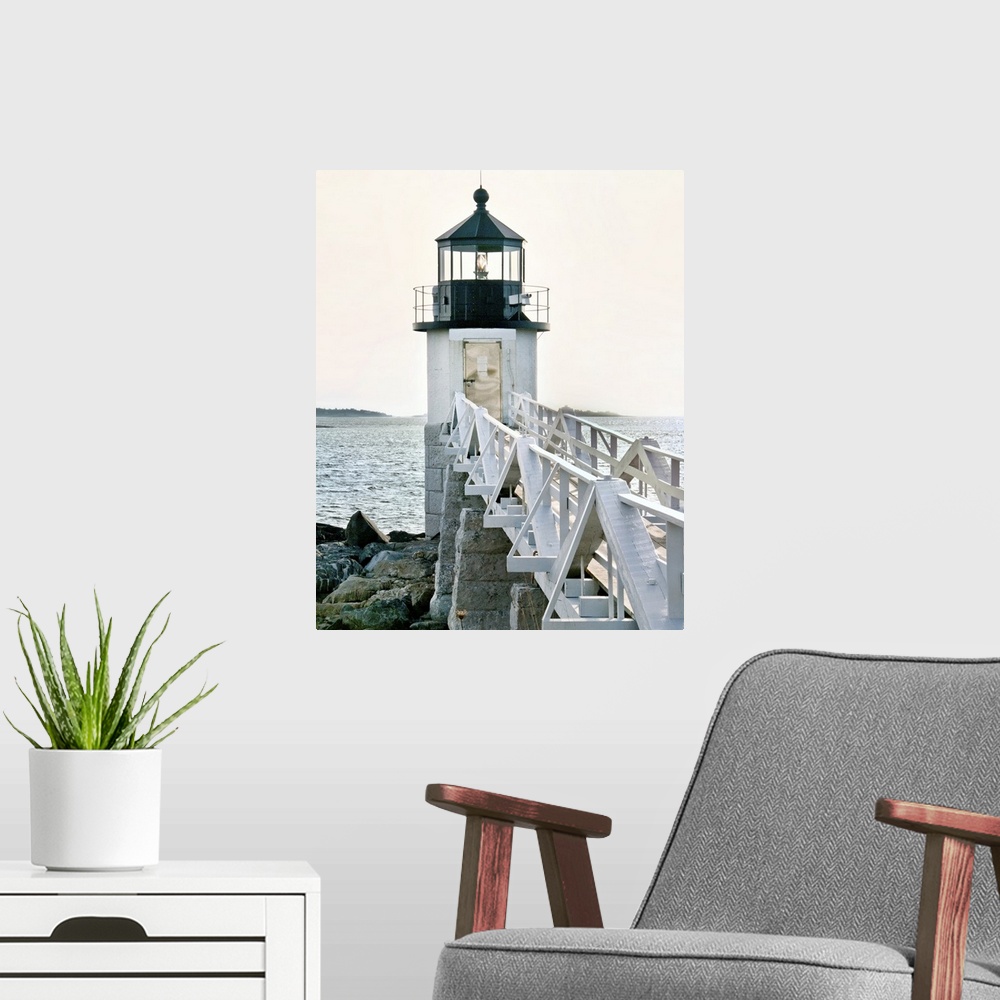 A modern room featuring A photograph of a lighthouse at the end of a pier jetting out over the water.