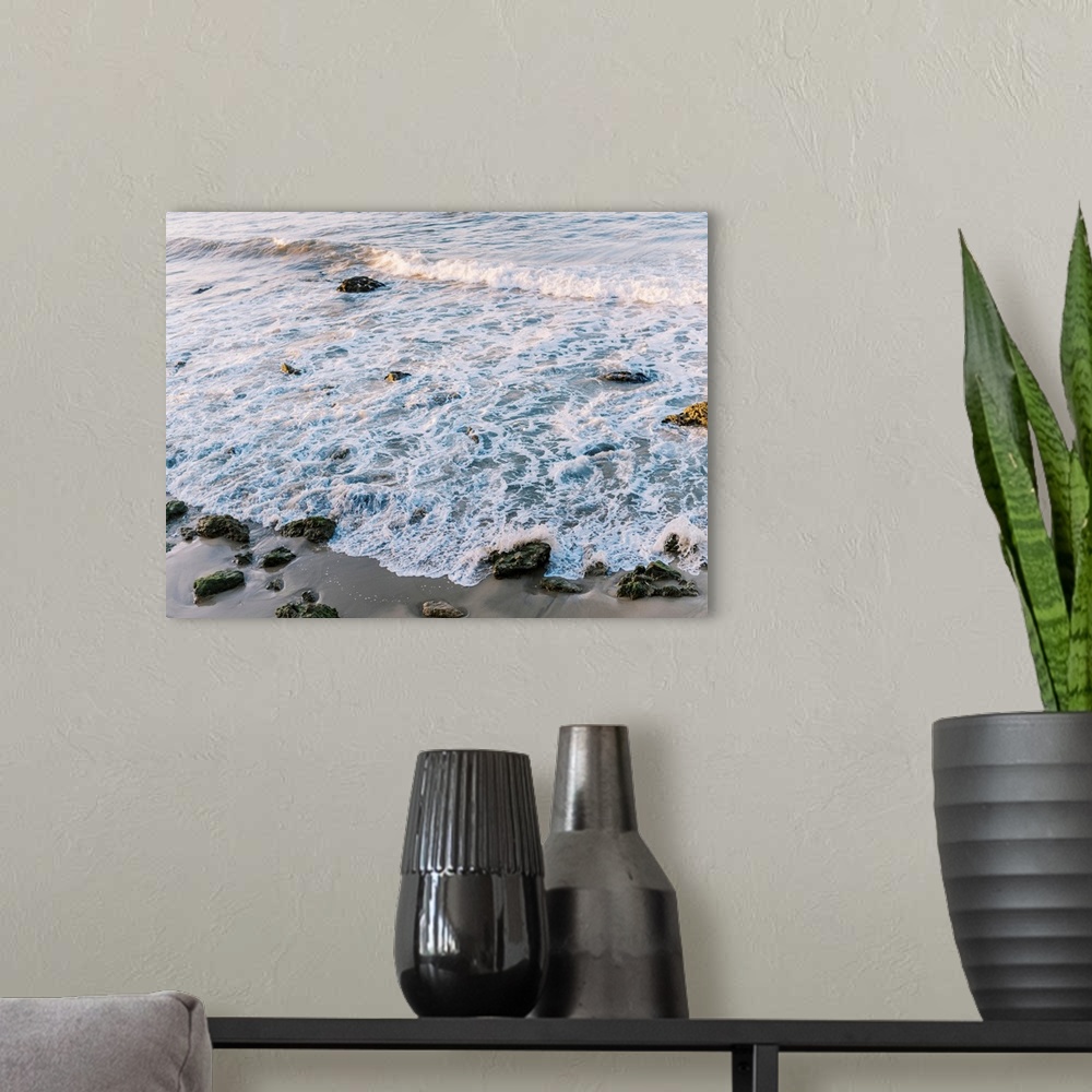 A modern room featuring A photograph of gentle waves lapping the beach.