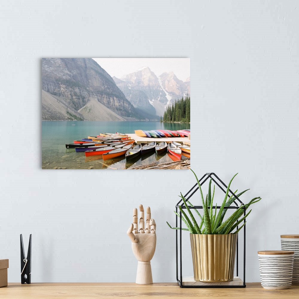 A bohemian room featuring A photograph of colorful canoes on the edge of Moraine Lake, Banff National Park, Alberta, Canada.