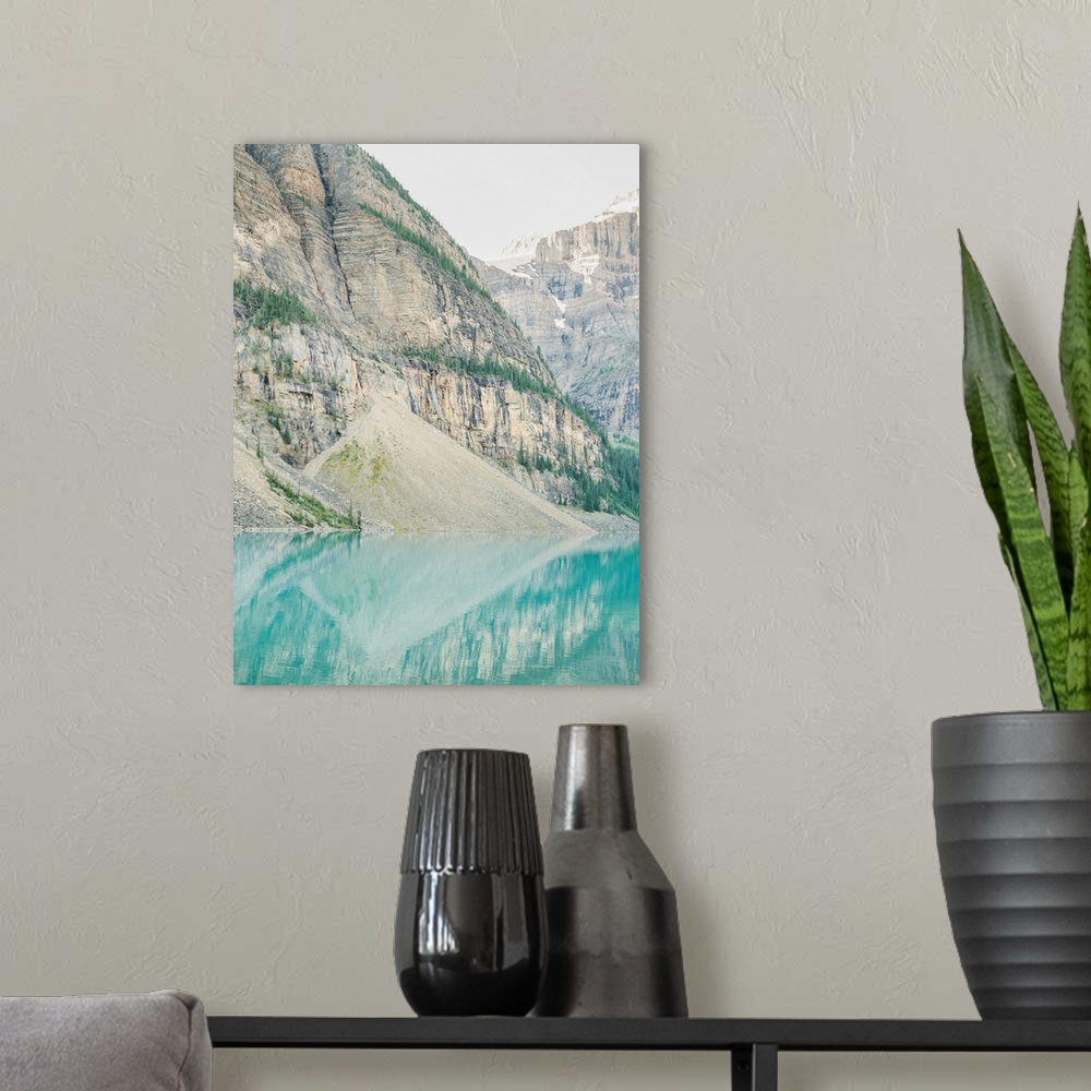 A modern room featuring A photograph of mountains reflecting in the clear blue water of Moraine Lake, Banff National Park...