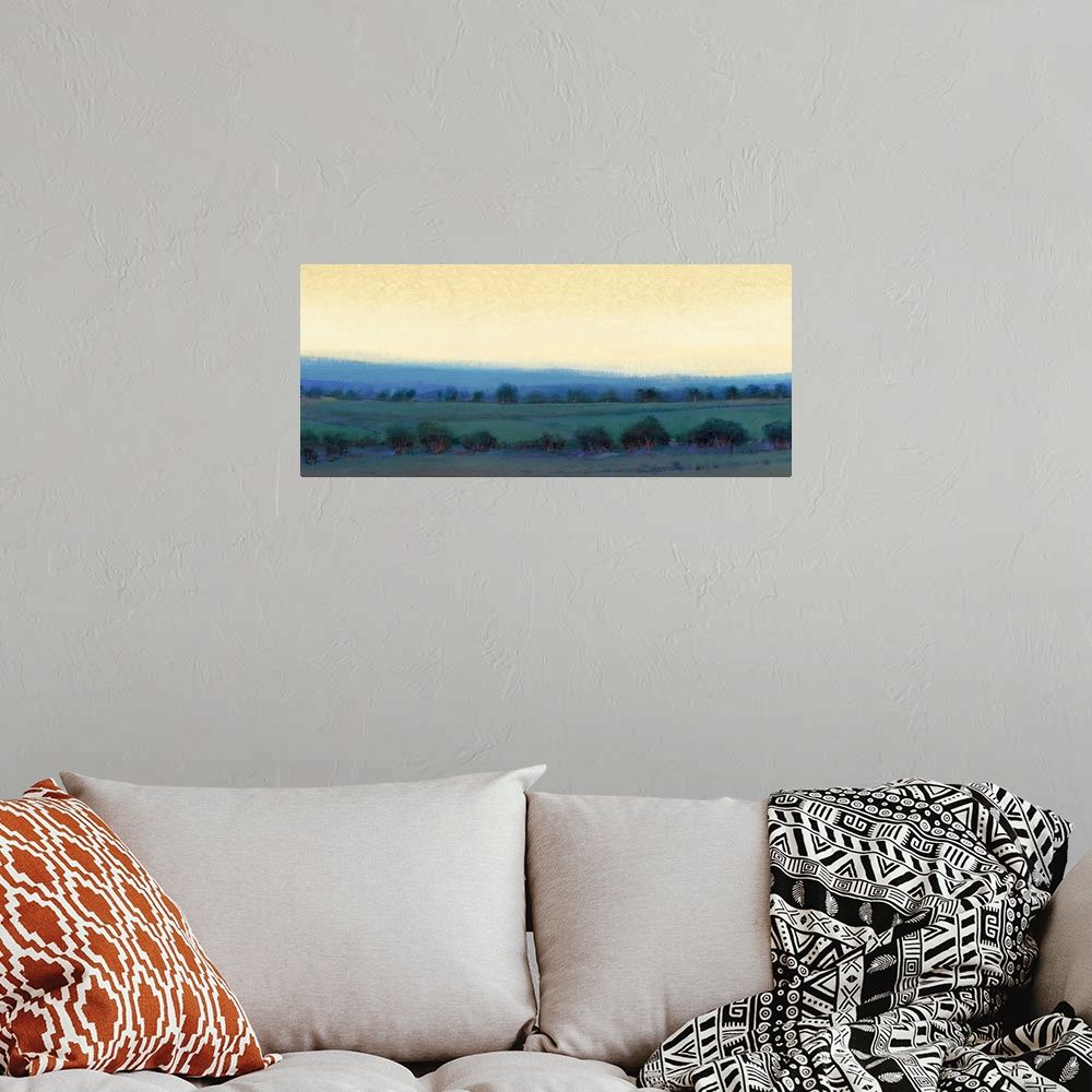 A bohemian room featuring Contemporary landscape painting of a pasture dotted with trees and a yellow sky overhead.