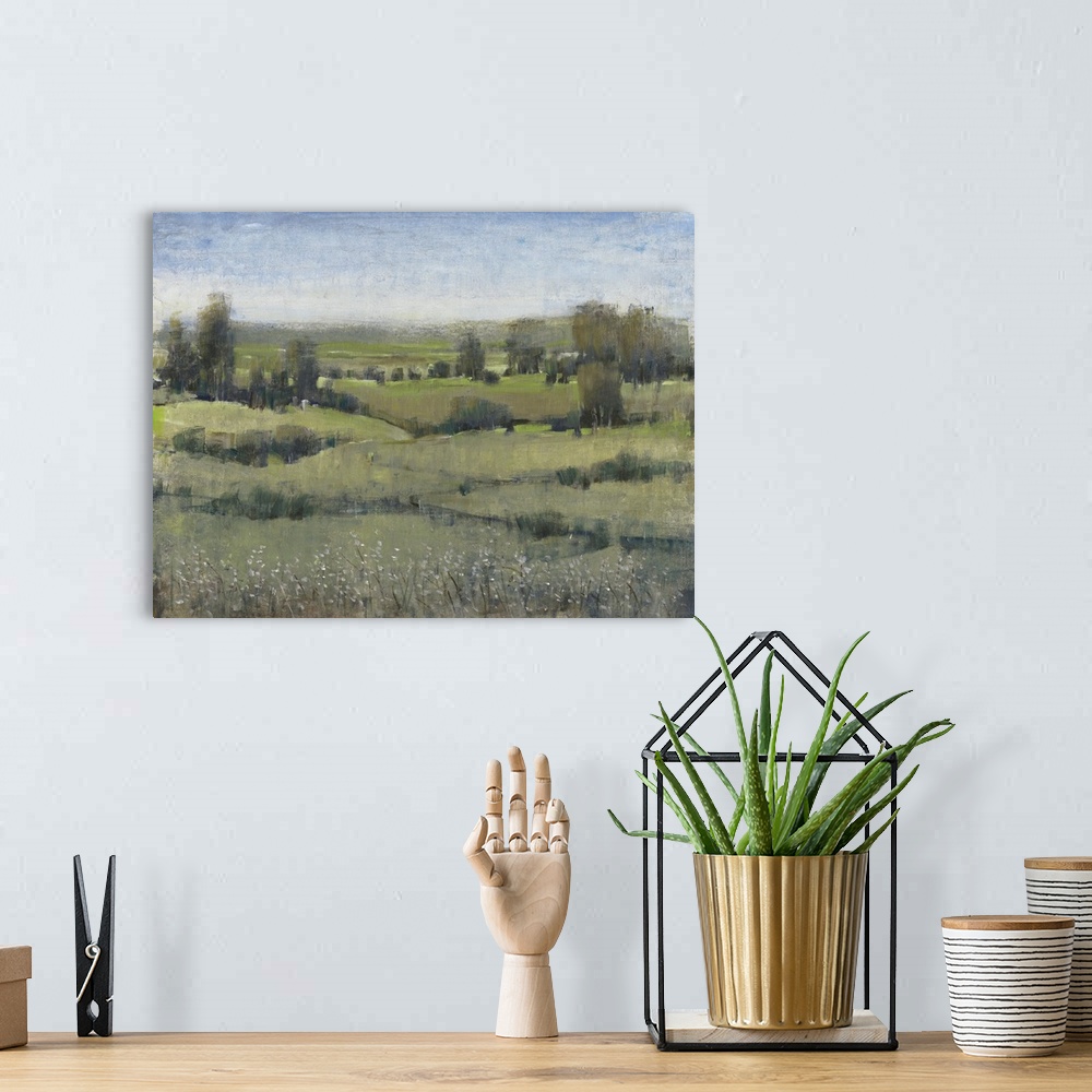 A bohemian room featuring Modern landscape artwork of verdant fields with trees under a blue sky.
