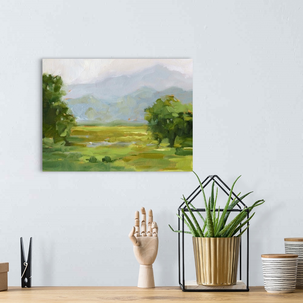 A bohemian room featuring Contemporary landscape artwork of a verdant countryside with mountains in the distance.