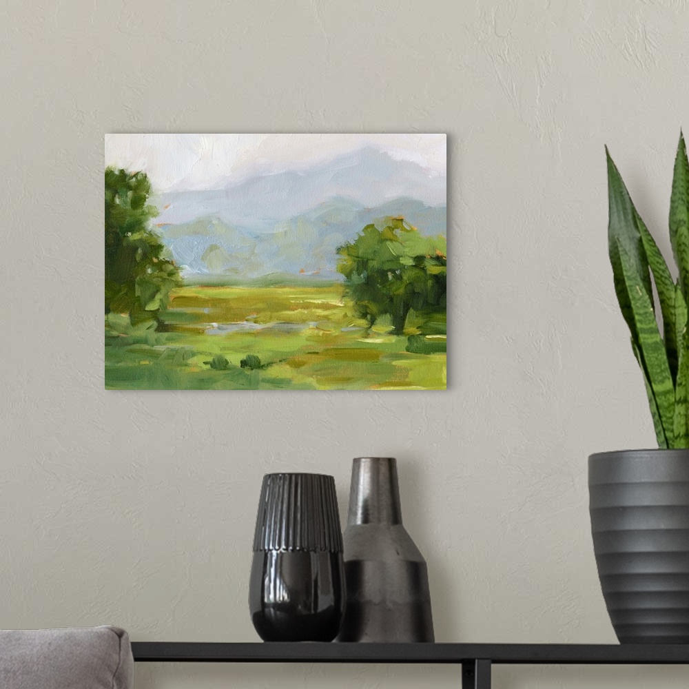 A modern room featuring Contemporary landscape artwork of a verdant countryside with mountains in the distance.