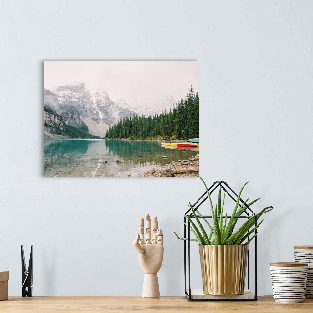 A bohemian room featuring A horizontal photograph of the mountains and trees reflected in Moraine Lake, Banff national park...