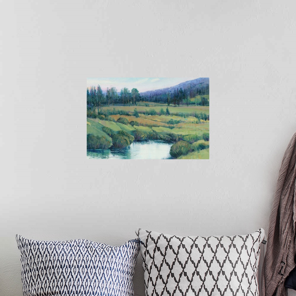 A bohemian room featuring Landscape painting of a tree lined meadow with a mountain range in the distance.