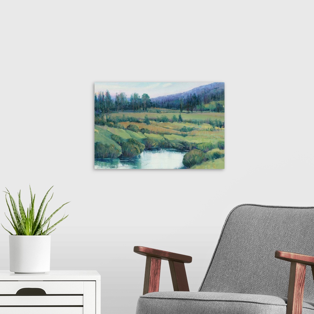 A modern room featuring Landscape painting of a tree lined meadow with a mountain range in the distance.