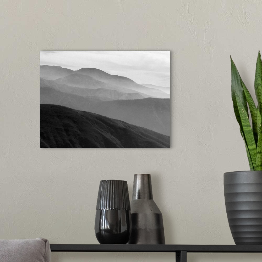 A modern room featuring A black and white photograph of a landscape of a silhouetted mountainous valley.