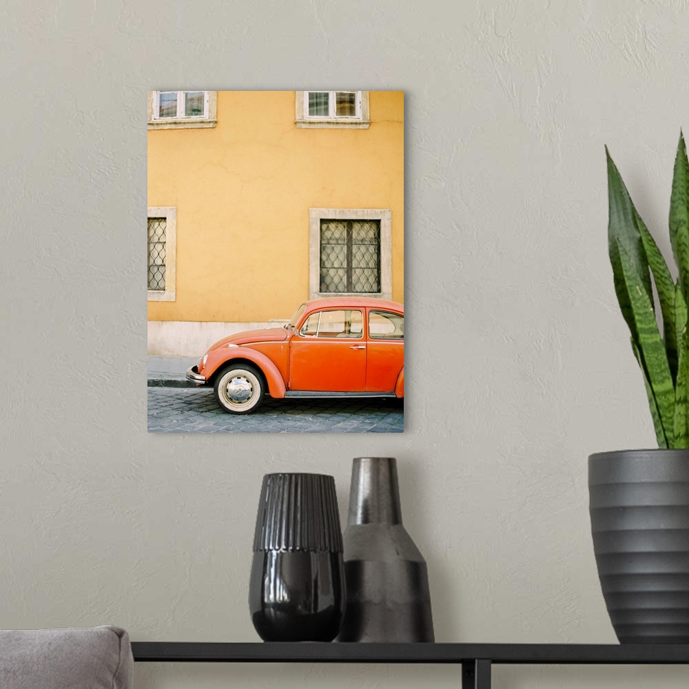 A modern room featuring Photograph of an orange Volkswagen Beetle car parked in front of a yellow wall, Budapest, Hungary.