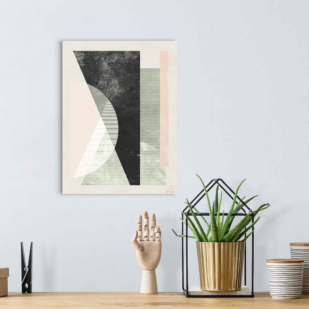 A bohemian room featuring Mid century style geometric artwork in black, grey, and pale pink.