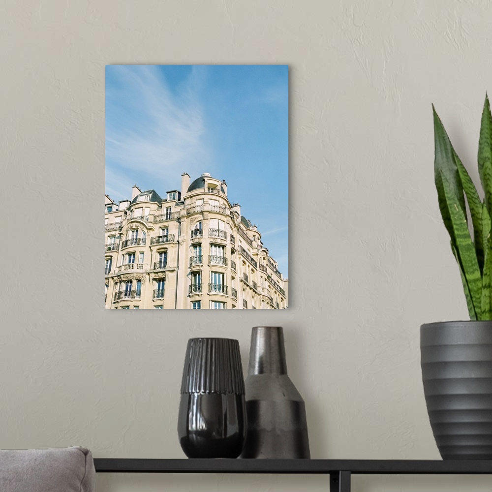 A modern room featuring Photograph of Paris apartments buildings beneath a blue sky.