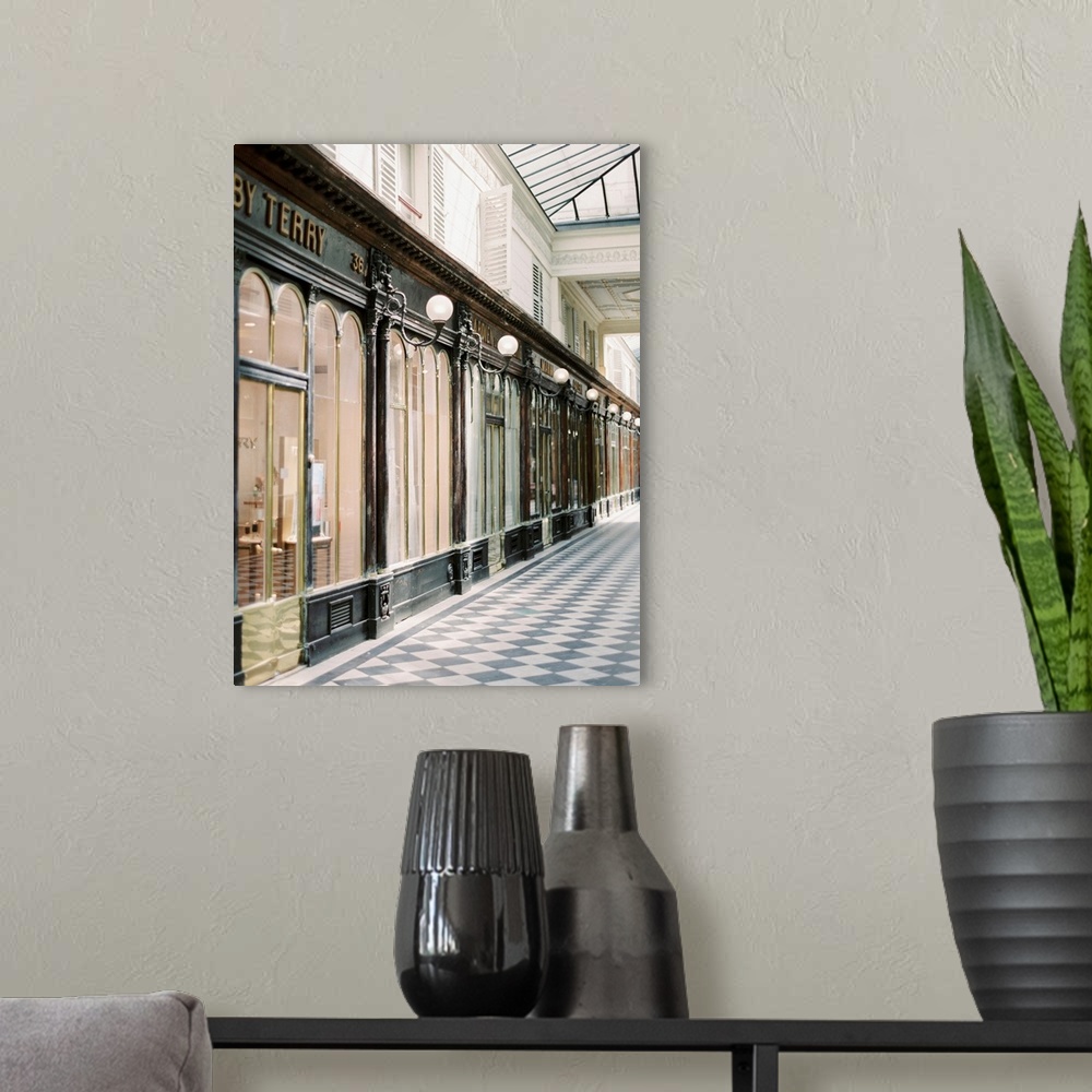 A modern room featuring A photograph of an arcade of stores in an elegant shopping district of Paris, France.