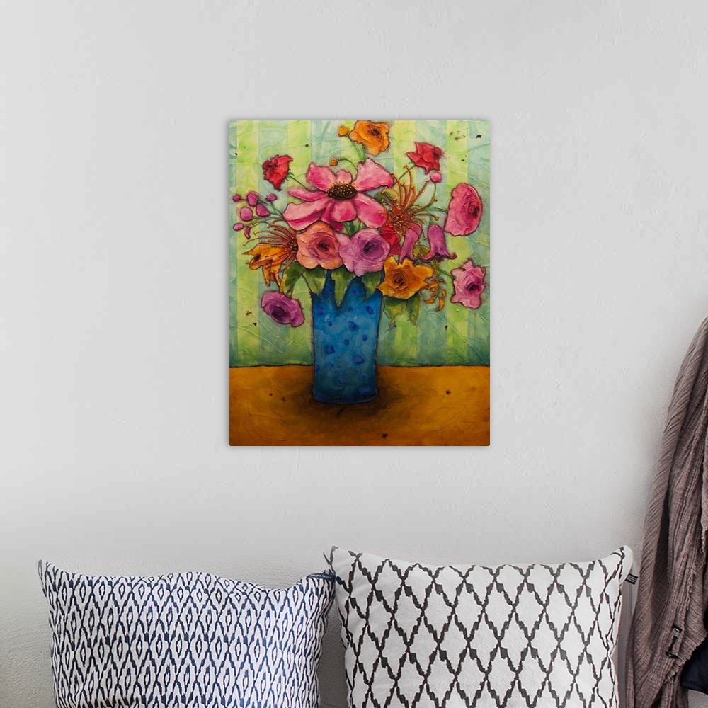 A bohemian room featuring A painting of a blue vase holding a bouquet of pink flowers.