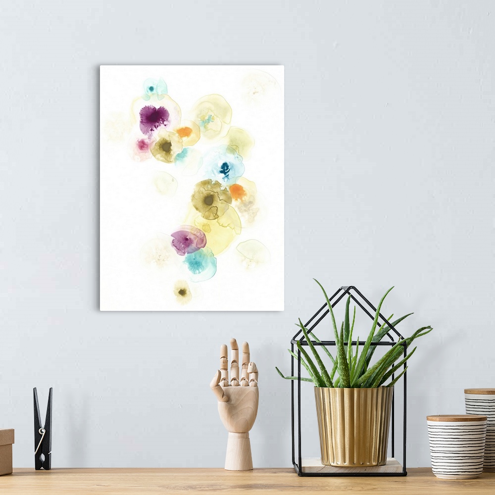 A bohemian room featuring Vertical artwork featuring watercolor droplets over a white background to resemble a petri dish.