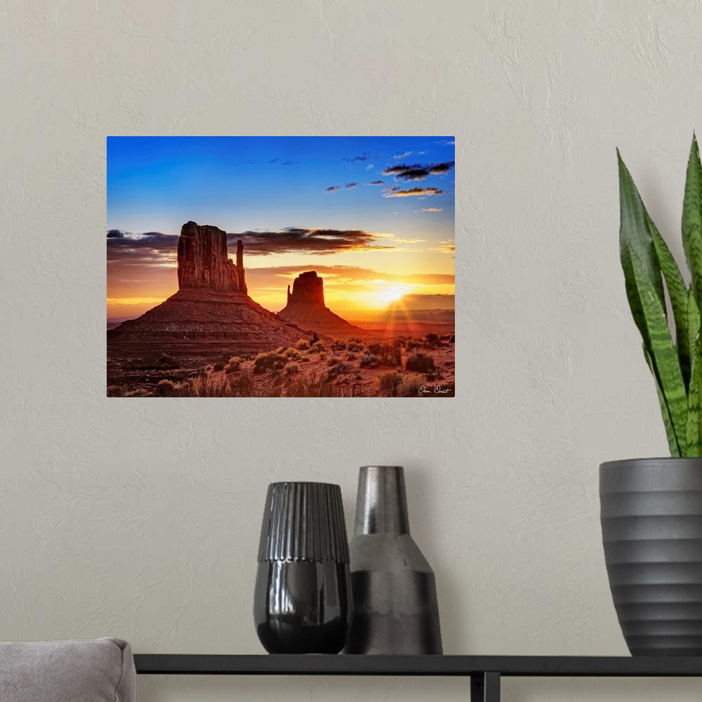 A modern room featuring Landscape photograph of the buttes at Monument Valley in Arizona with a bright sunset in the back...