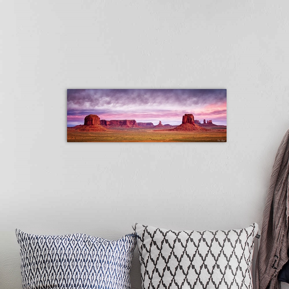 A bohemian room featuring Panoramic photograph of Monument Valley with a pink and purple sunrise above.