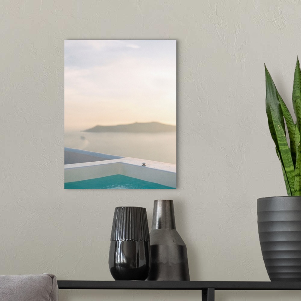 A modern room featuring Photograph of the edge of a swimming pool with an island in the distance, Santorini, Greece.