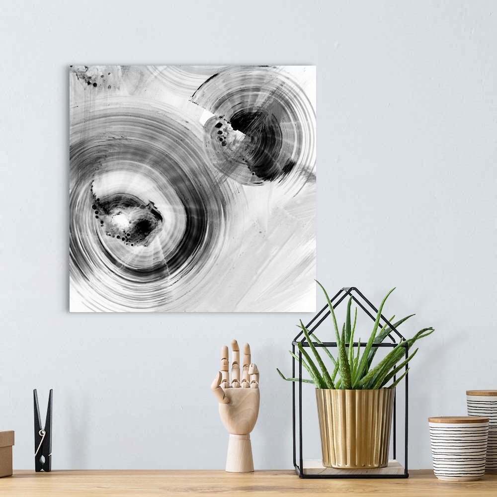 A bohemian room featuring Contemporary abstract painting of circular forms in white and black reminiscent of water's ripple...