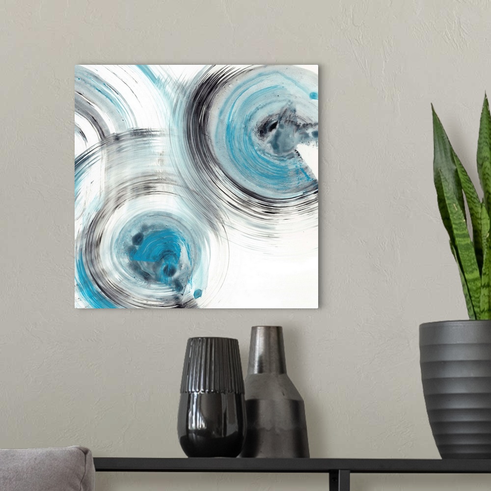A modern room featuring Contemporary abstract painting of circular forms in blue and black reminiscent of the ripple effe...