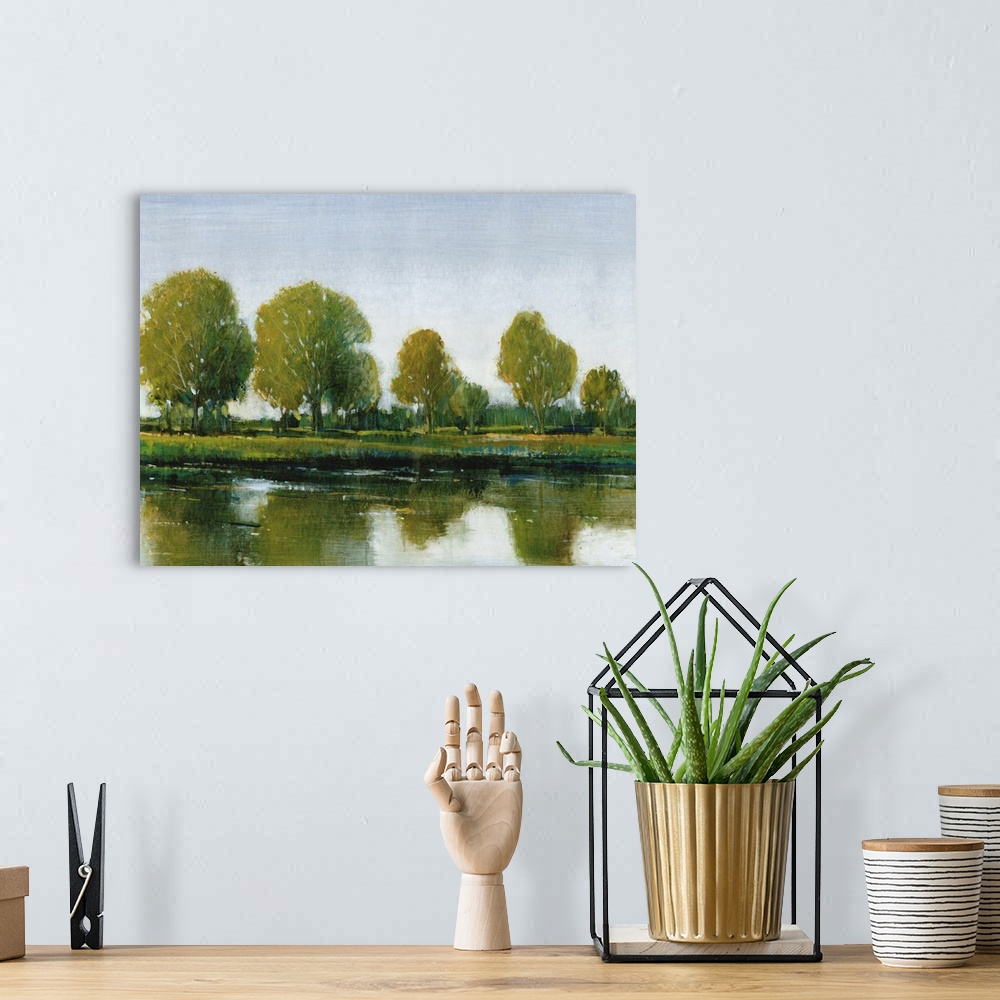 A bohemian room featuring Contemporary painting of an idyllic countryside scene of trees reflected in still water.