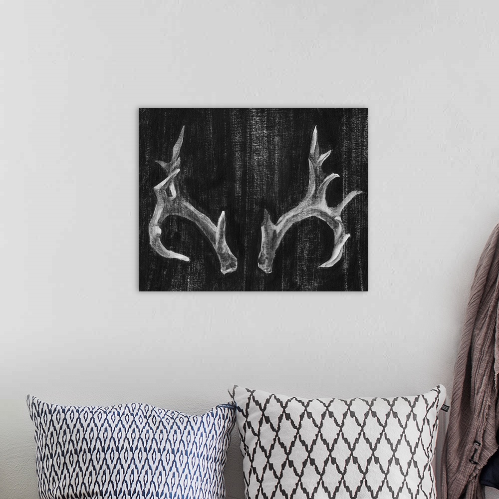 A bohemian room featuring Contemporary artwork of a set of large pronged antlers.