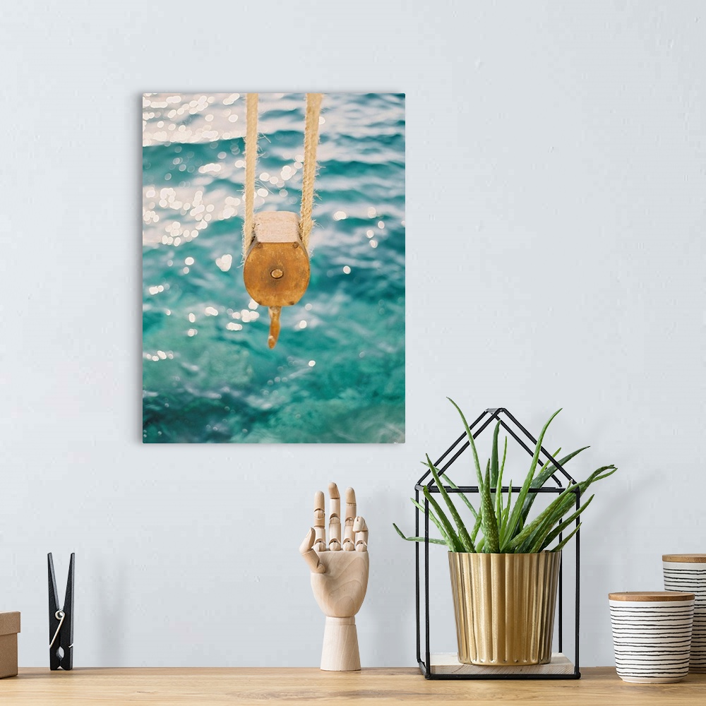 A bohemian room featuring Photograph of a tackle block hanging over the clear blue water, Santorini, Greece.