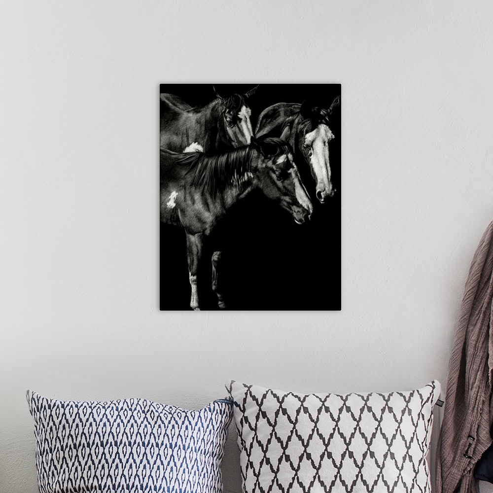 A bohemian room featuring Black and white illustration of three horses standing together.