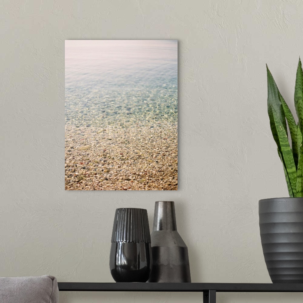 A modern room featuring Photograph of shallow ocean water on a pebble beach, Corfu, Greece.